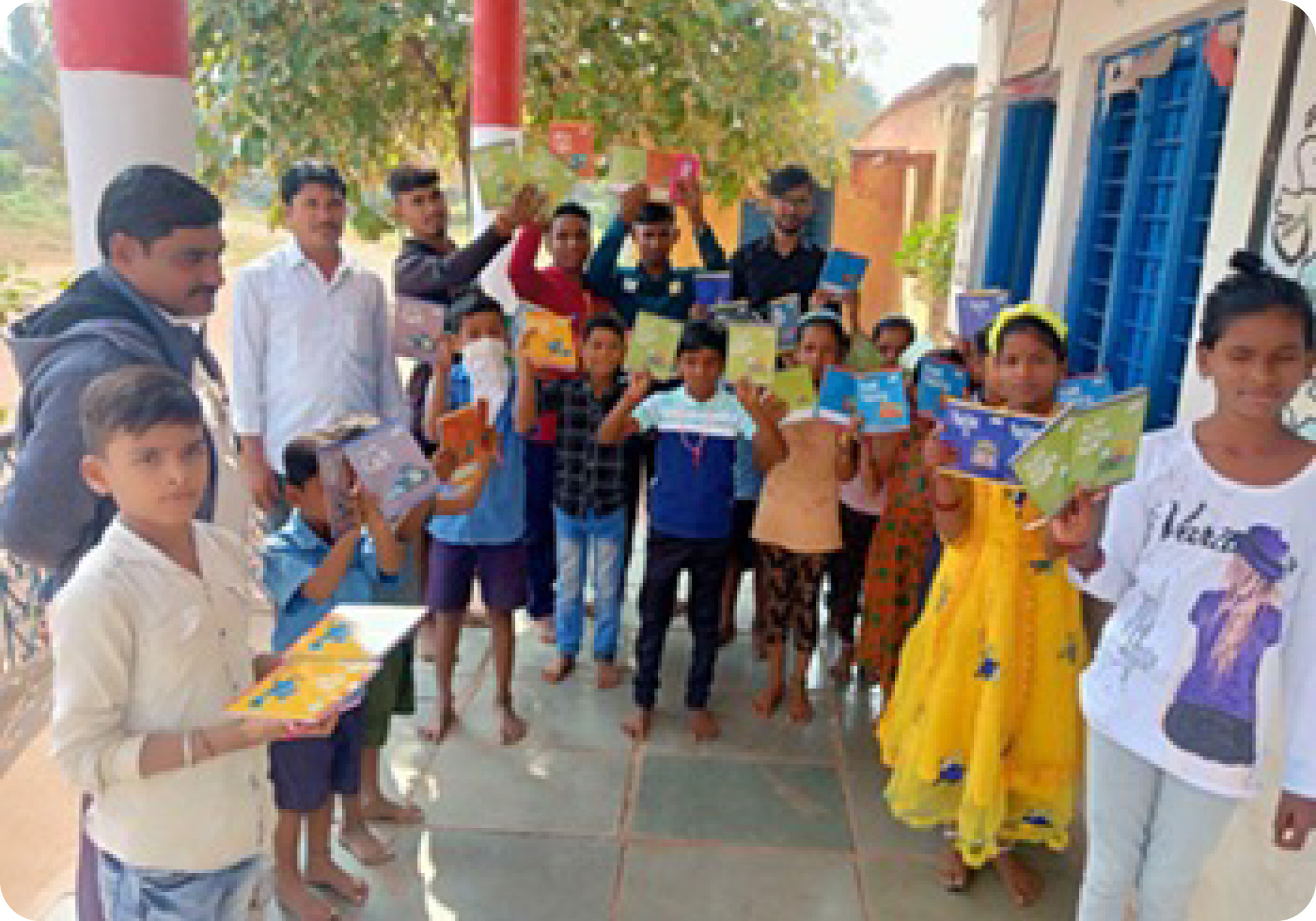 Group photo of students receiving donated notebooks and pens
